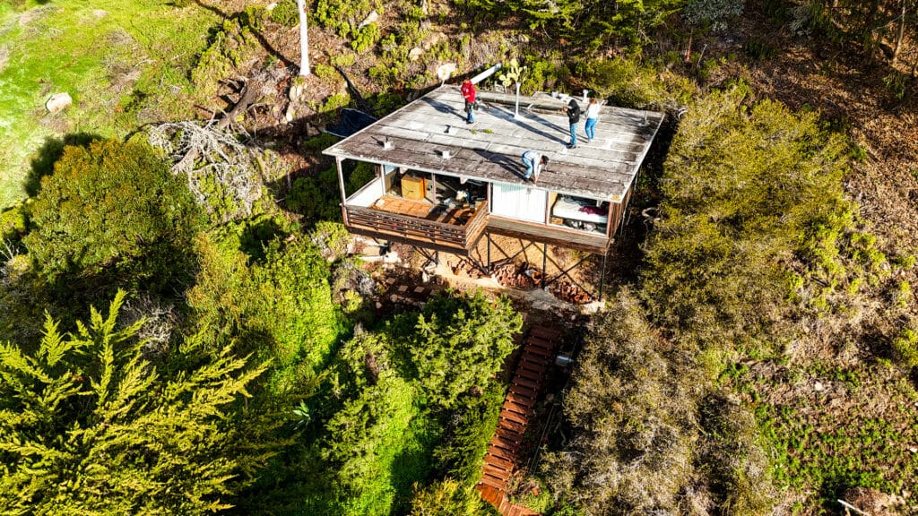 Aerial view of cabin surrounded by trees.