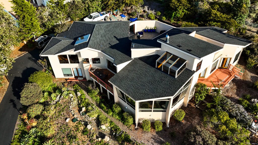 Modern house with lush garden, aerial view.