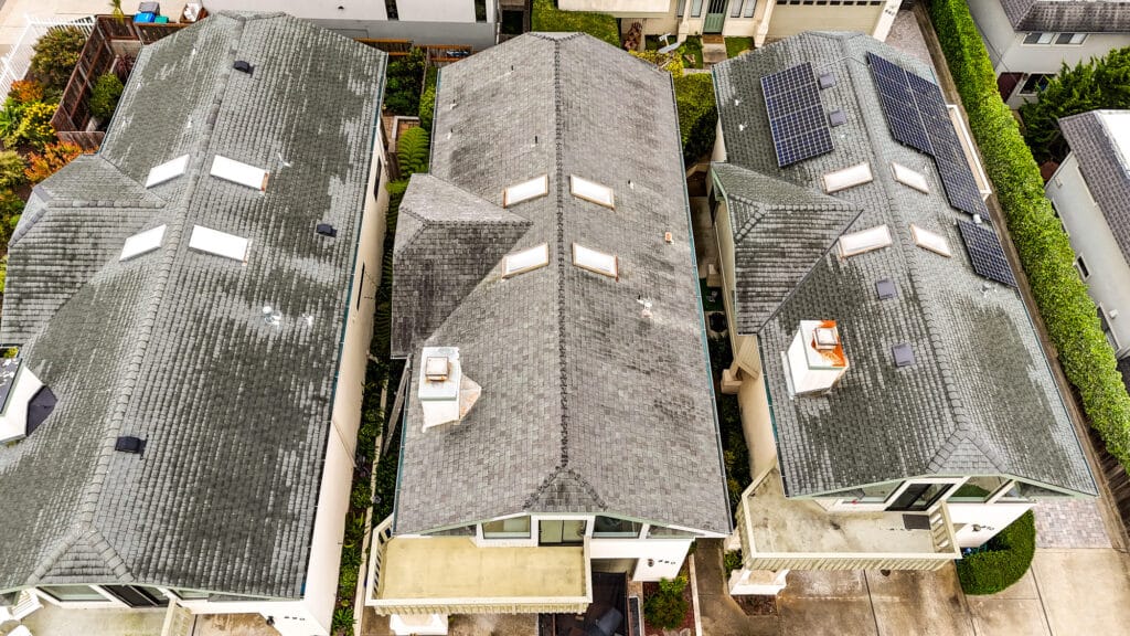 Aerial view of residential rooftops with solar panels.